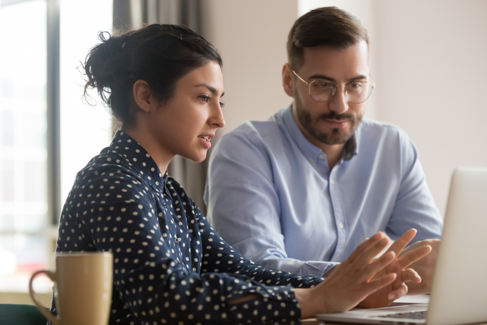 Man and woman chatting in front of laptop